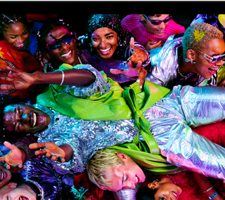 Ein MacBook Pro Display zeigt ein farbenfrohes Bild einer Person, die auf einer Party crowdsurft, und demonstriert das brillante Liquid Retina XDR Display