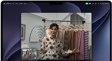 Ein Videoanruf auf einem MacBook Pro, in dem eine Frau zwei Personen Stoffe zeigt, während die Automatische Ausrichtung dafür sorgt, dass sie in der Mitte des Bildes bleibt, auch wenn sie sich durch den Raum bewegt