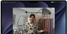 Ein Videoanruf auf einem MacBook Pro, in dem eine Frau zwei Personen Stoffe zeigt, während die Automatische Ausrichtung dafür sorgt, dass sie in der Mitte des Bildes bleibt, auch wenn sie sich durch den Raum bewegt